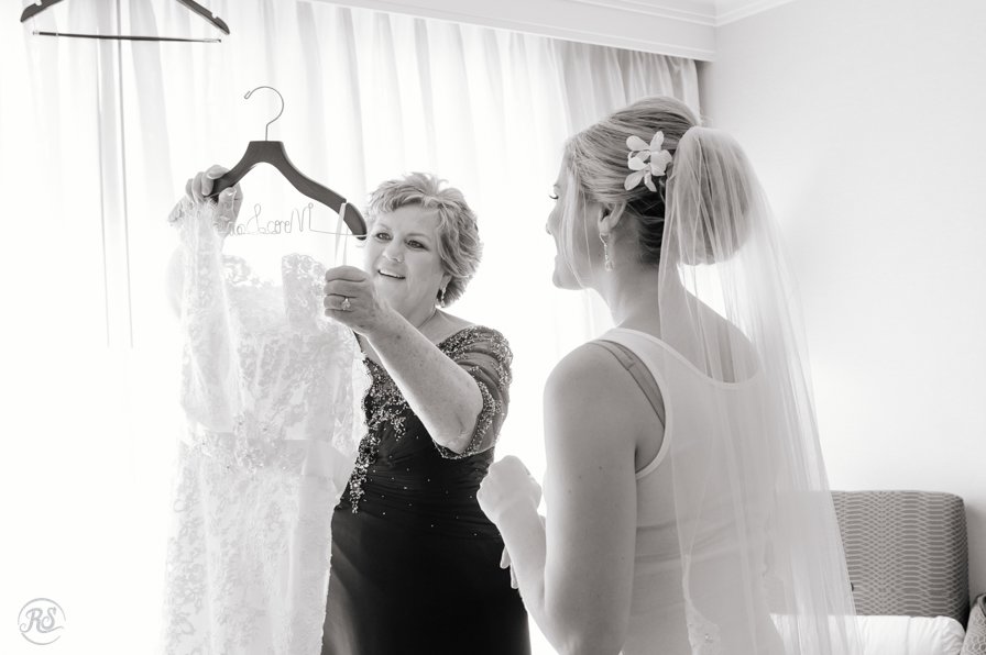 mother of bride helping bride with dress