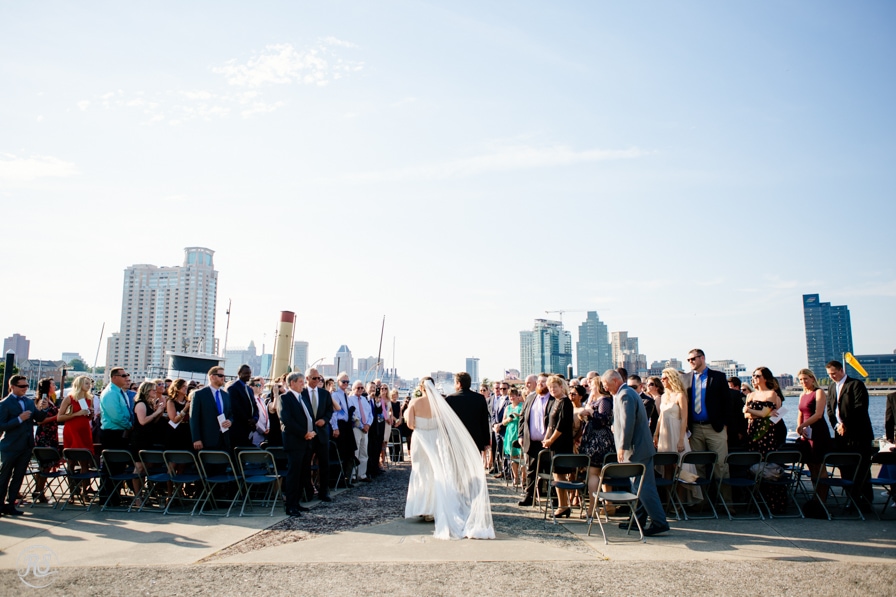 Bride walking down aisle, Baltimore skyline ceremony site 
