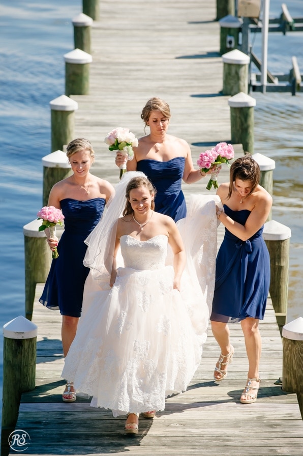 bride walking on dock with bridesmaids 