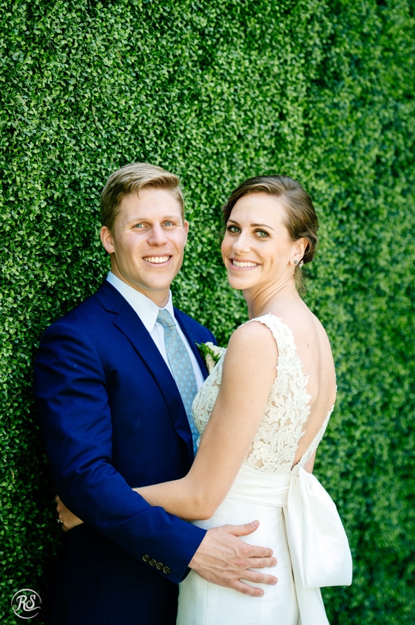 Bride and Groom by the boxwood wall 
