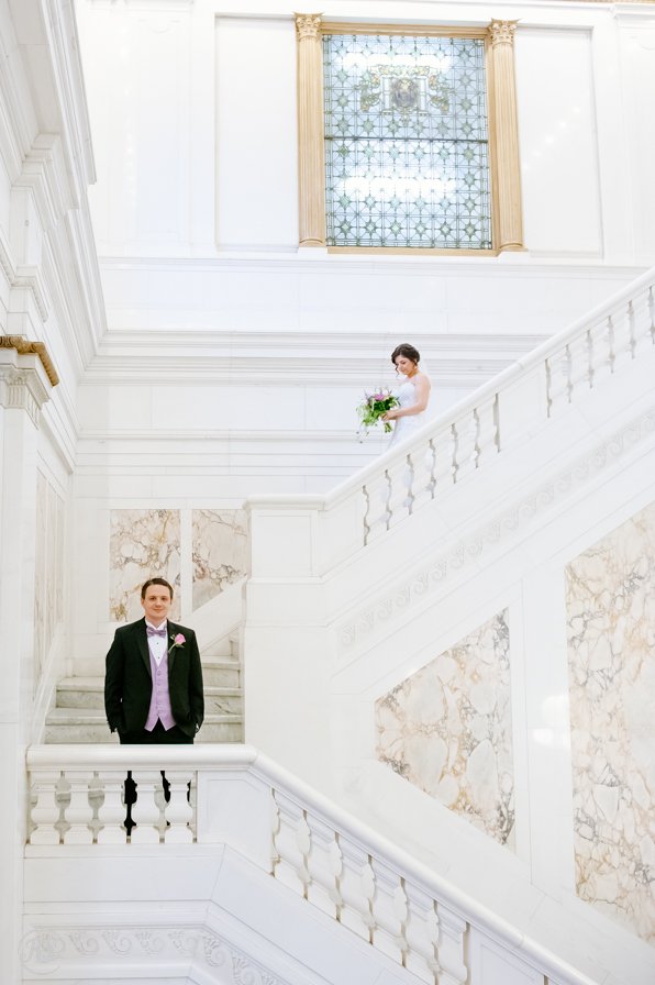Bride walking to groom on staircase for first look