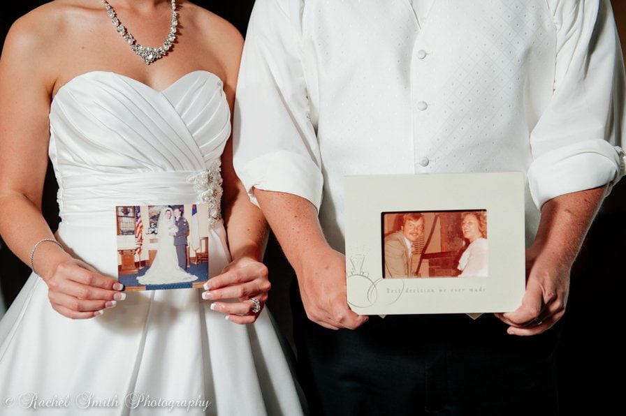 bride and groom holding photo of their parents on their wedding day