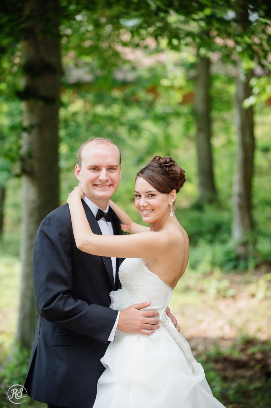 Bride with arms wrapped around groom's neck