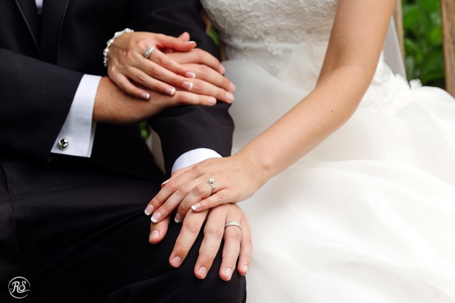Bride and Groom Holding Hands with wedding bands