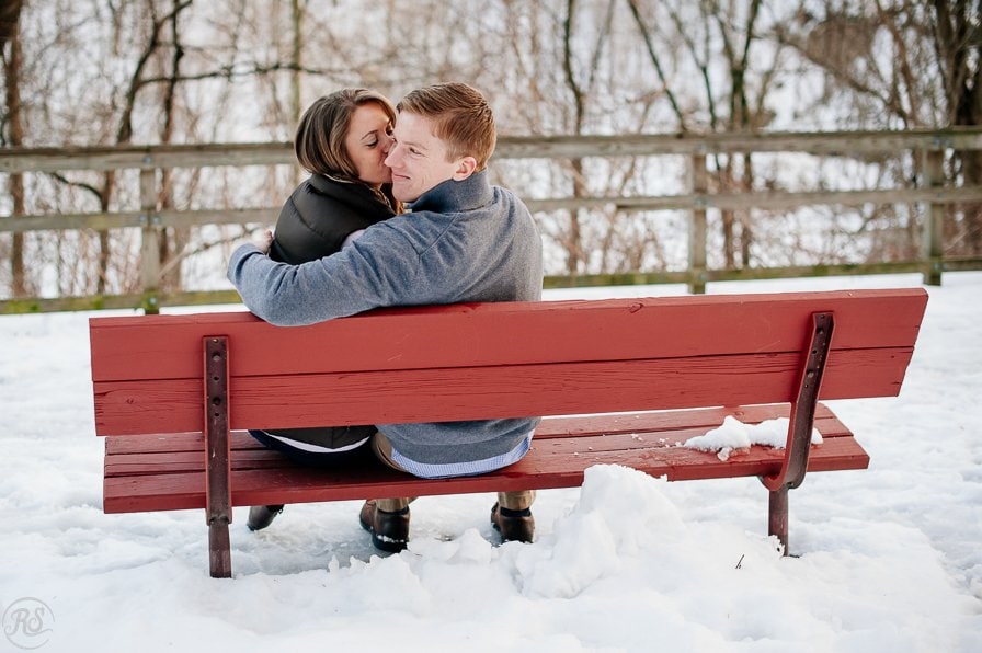 Winter Snow Engagement Photos, Couple on Red Bench
