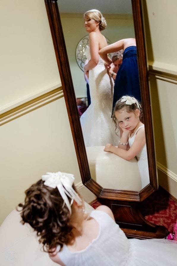 Flower girl looking at bride in mirror