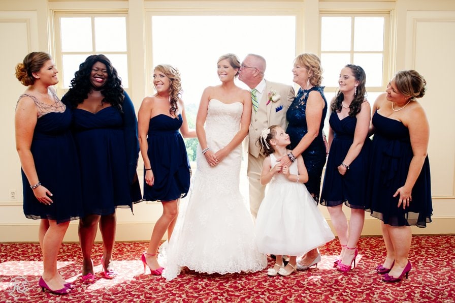 Bride with her girls and family. Dad sneaks a kiss