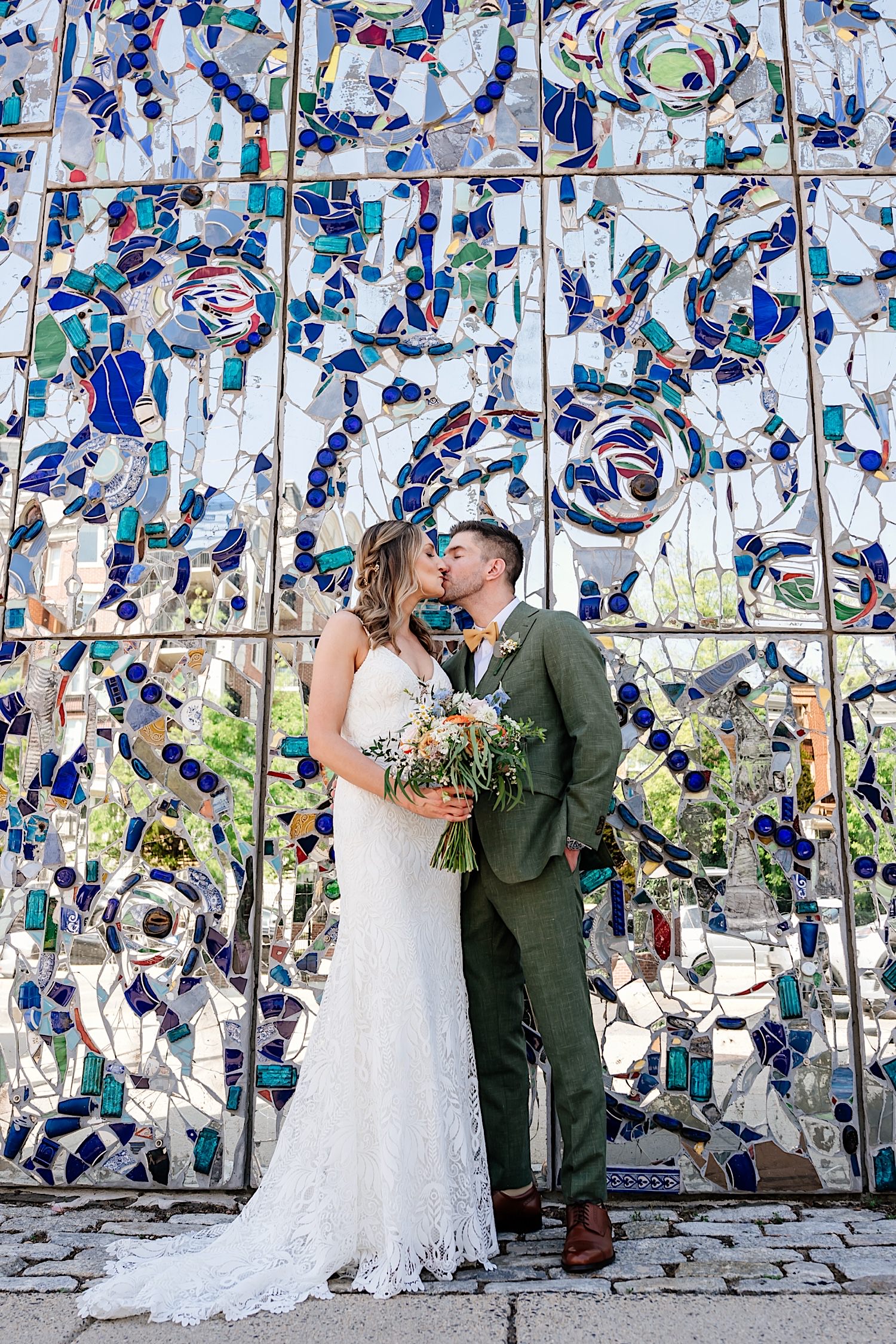 bride and groom photo of kiss in front of art wall