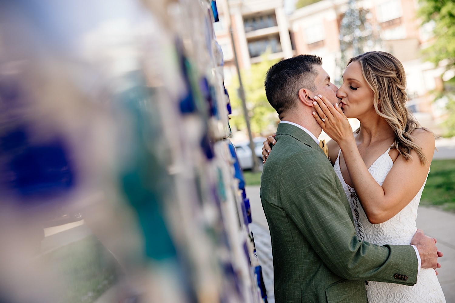 bride and groom kissing at glass mosaic wall