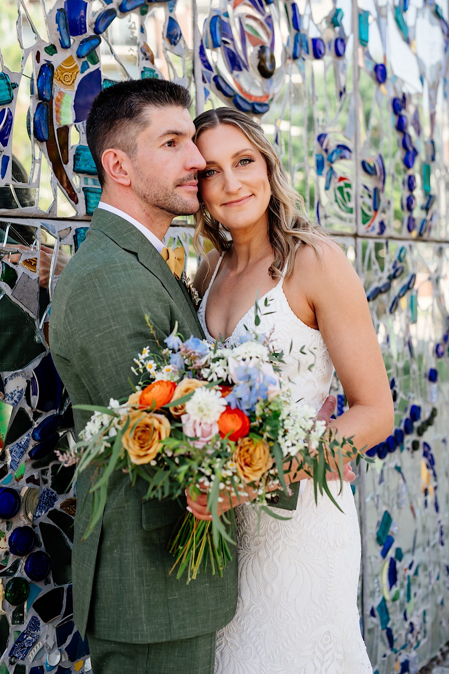 wedding day photo at American visionary art museum with color flowers and background