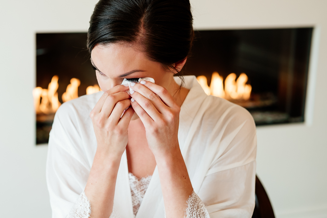 bride wiping tears of joy from eyes