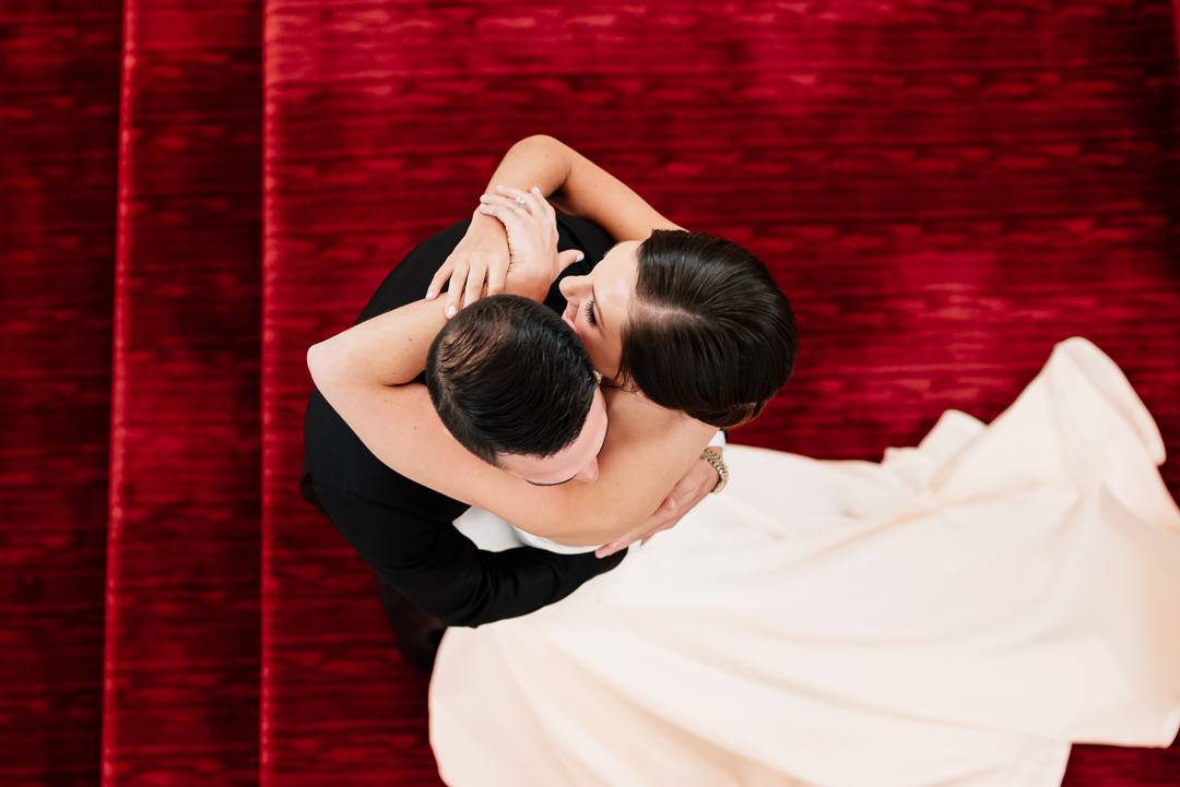 creative angle of bride and groom embracing after first look on the staircase at the sagamore pendry