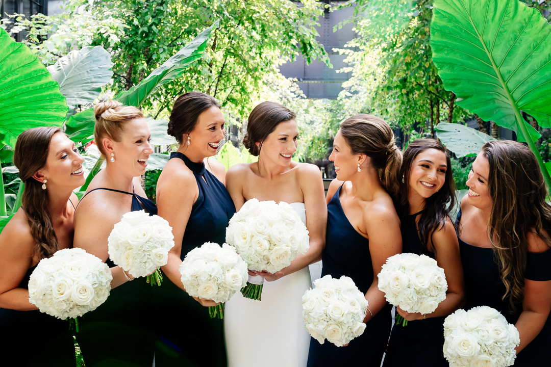candid portrait of bride with bridesmaids in atrium