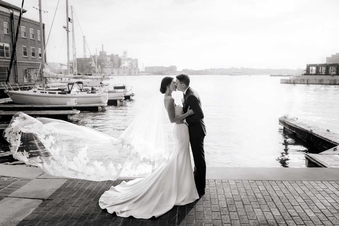 bride and groom kissing on the waterfront in fells point baltimore