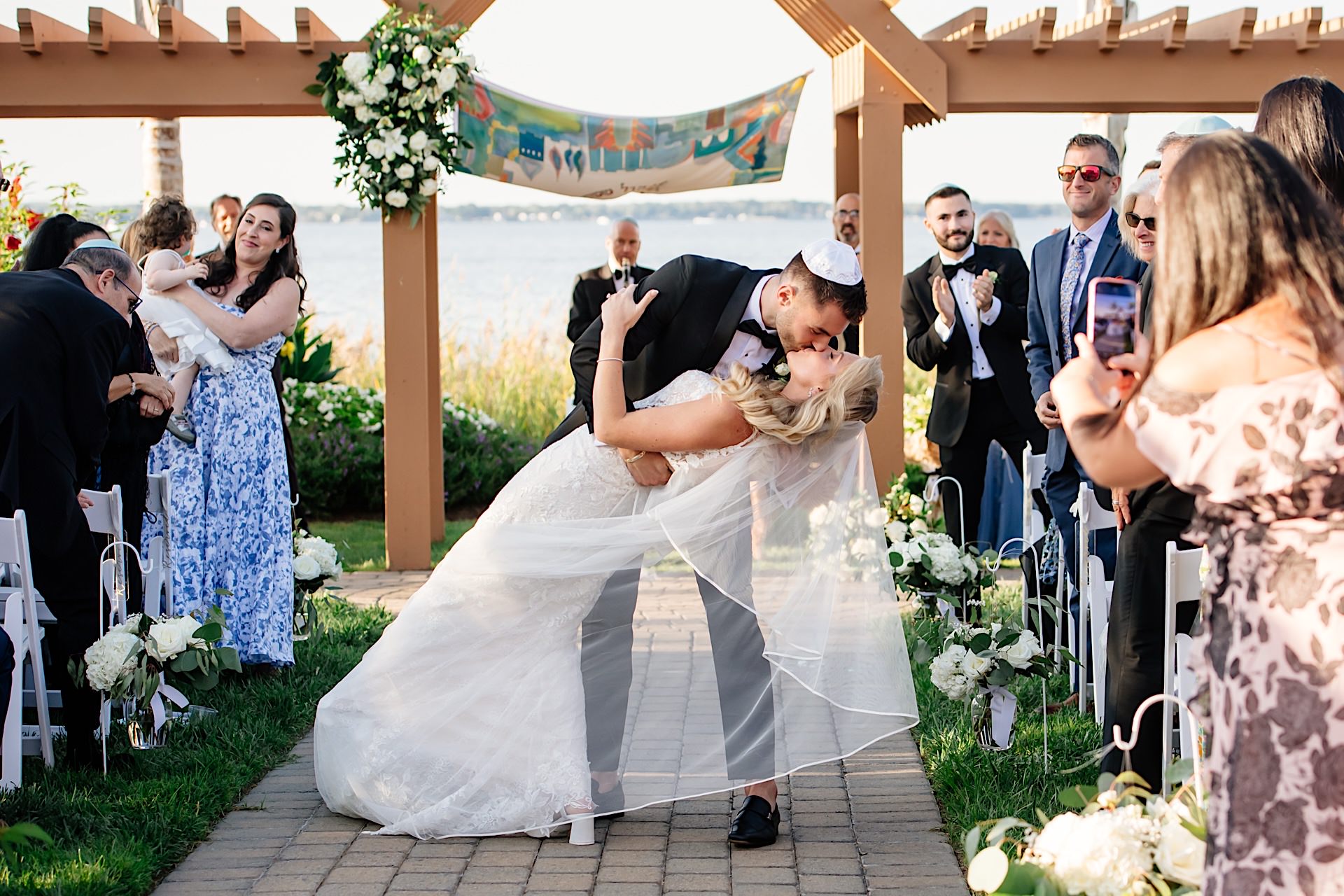 groom dips bride after wedding ceremony at herrington on the bay