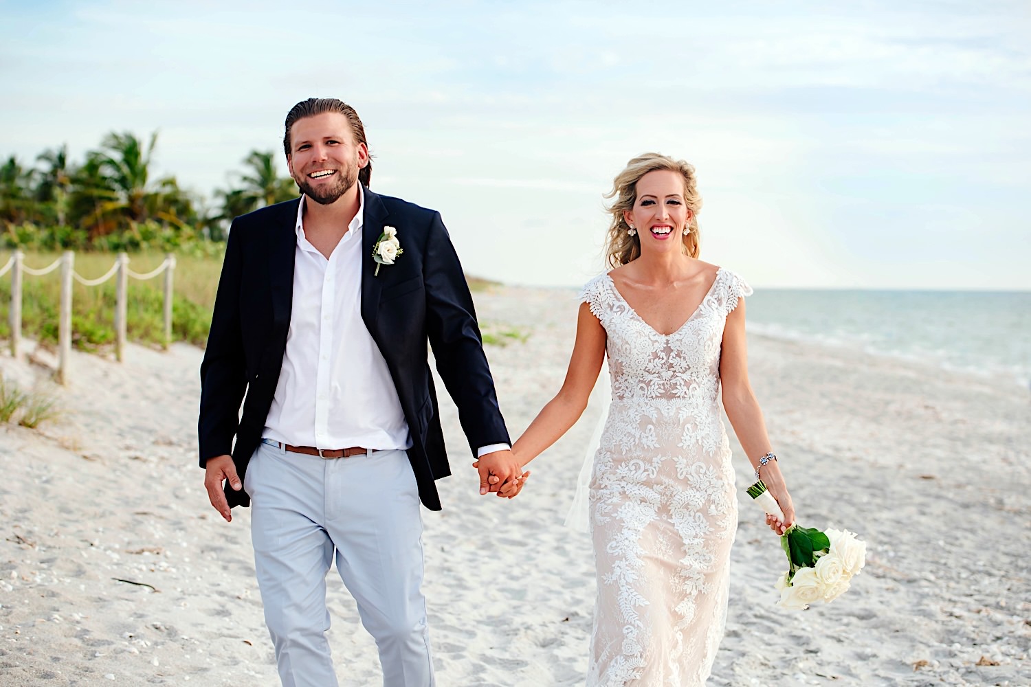 bride and groom laughing and walking along the island beach