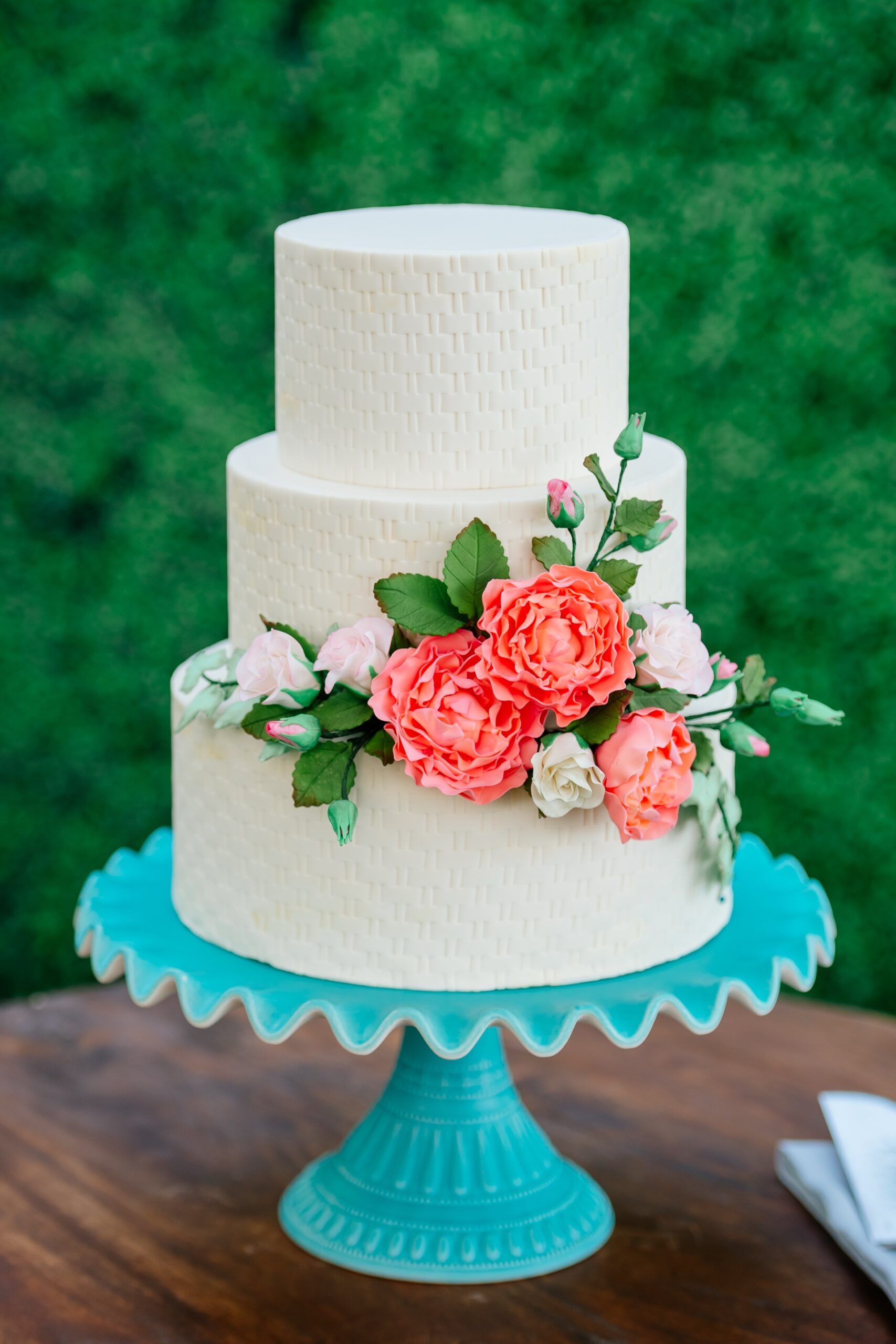 simple yet elegant wedding cake on blue cake stand created by Steve Konopelski Patissie